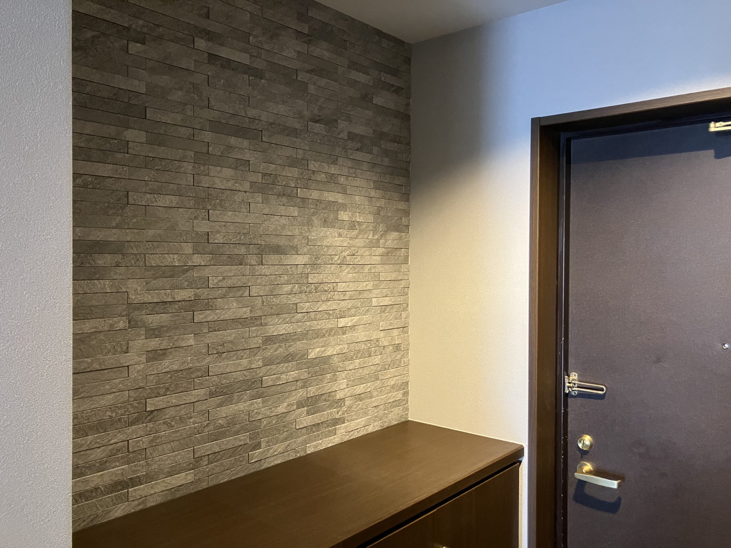 玄関は石積調のクロスを採用