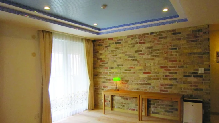 Cozy room with a brick accent wall, wooden console table, and a green desk lamp.
